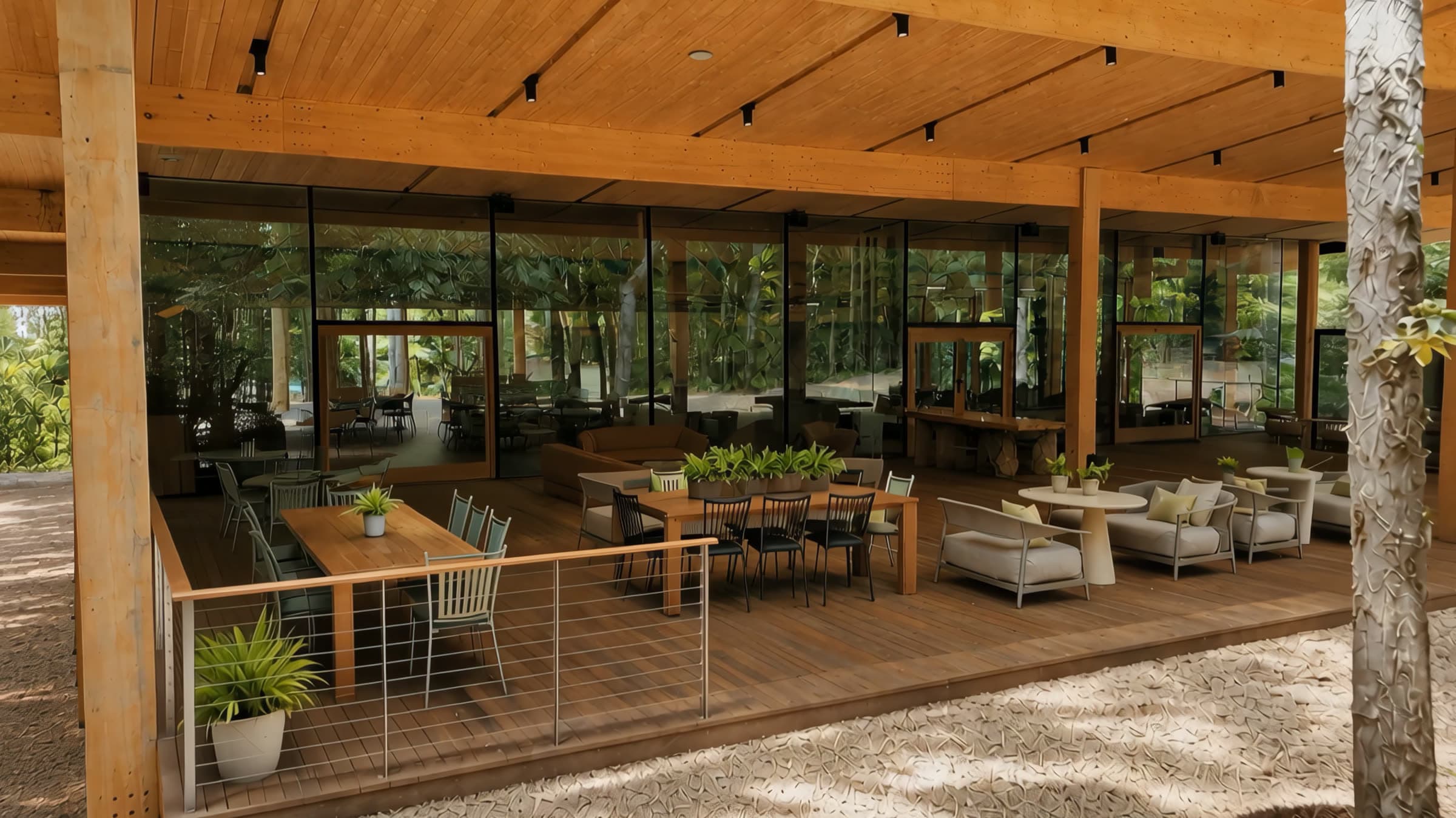 The Aviary pavilion — tables and lounge seating on the deck under the timber roof, forest on every side