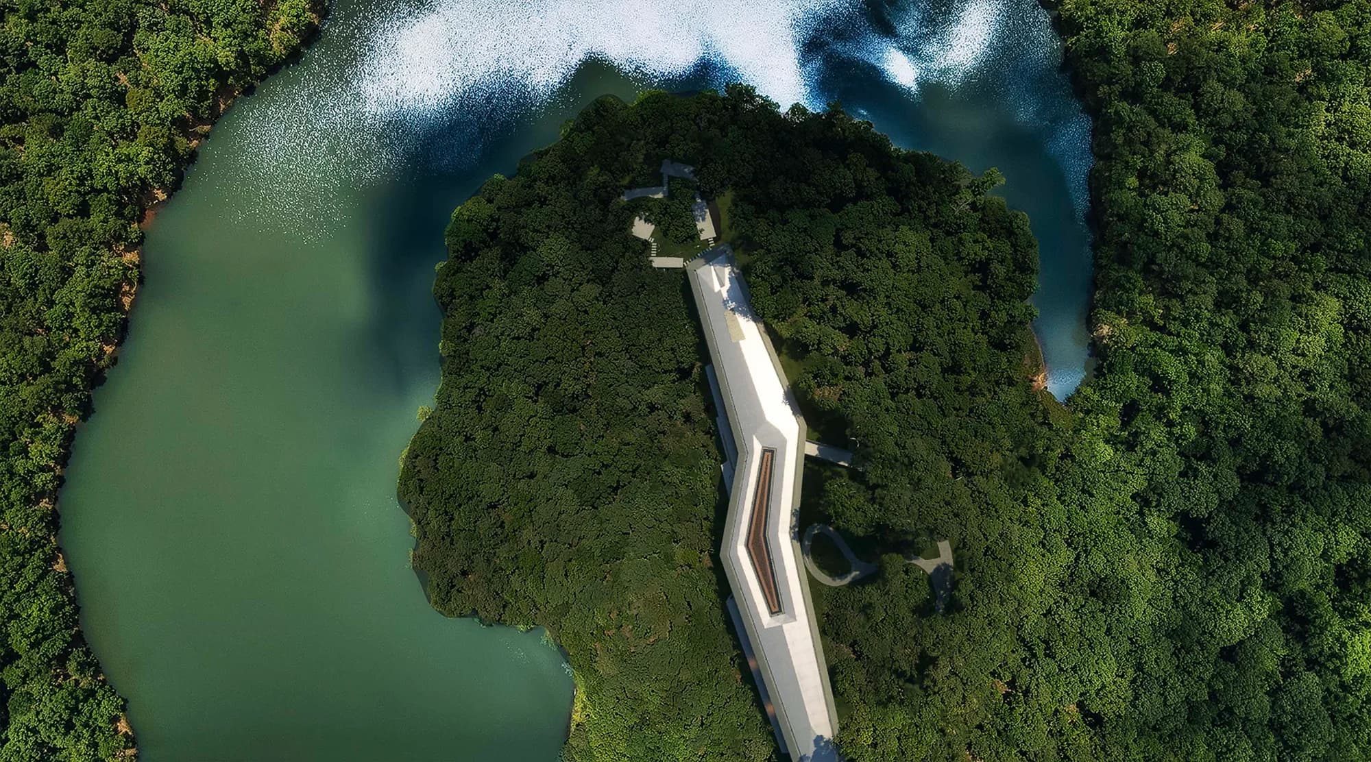 Looking straight down on the estate: a long white building on a wooded peninsula between two lakes